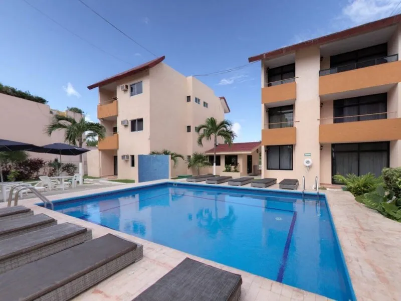 Osrednji bazen z ležalniki pod modrim nebom